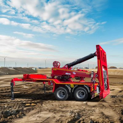 Red jeep dolly by DOLL at a wind turbine construction site with windmills and a crane in the background.