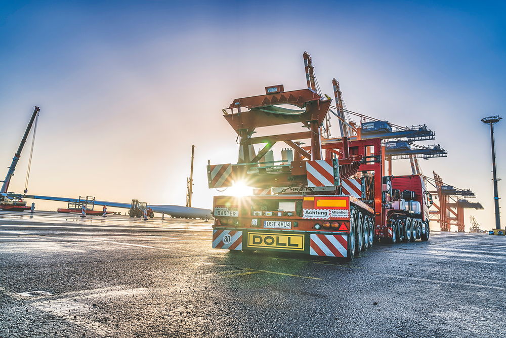 Véhicule de transport lourd de DOLL pour éoliennes au port au lever du soleil