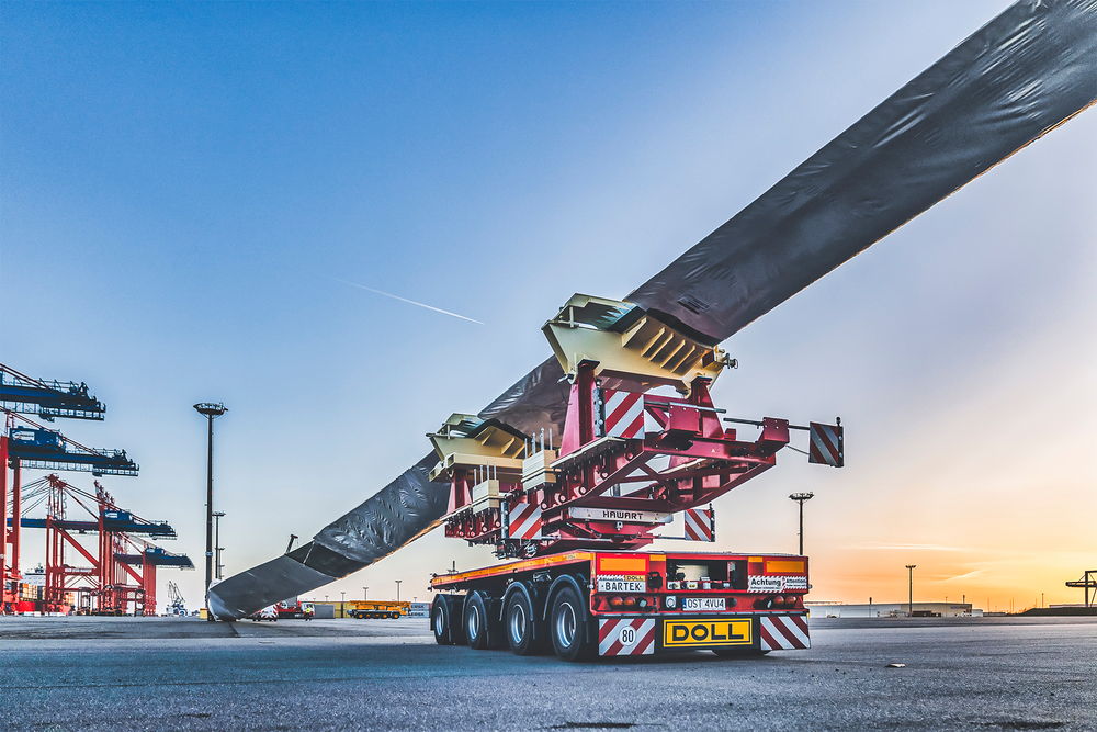 Véhicule de transport lourd de DOLL pour les éoliennes du port au coucher du soleil